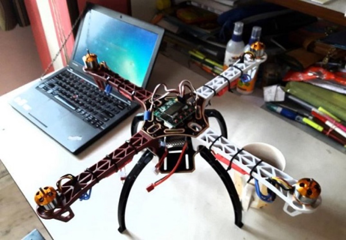 DIY 330 mm quadcopter on the workbench without propellers, next to a laptop